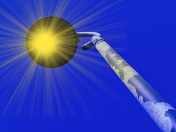 Low angle view of electric lamp against blue sky on sunny day