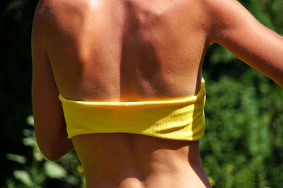 Rear view of woman wearing yellow bikini