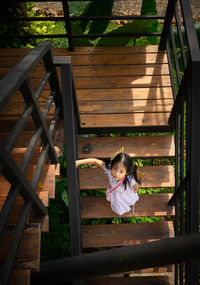 High angle portrait of girl moving down on steps at playground