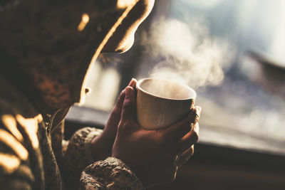 Midsection of woman holding coffee cup