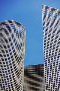 Low angle view of modern buildings against clear blue sky