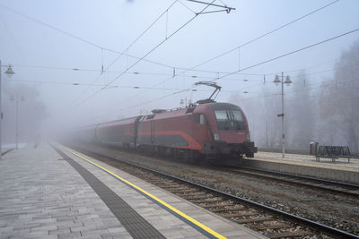 Train at railroad station against sky