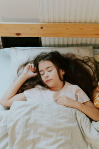 Little caucasian girl sleeps sweetly in bed.