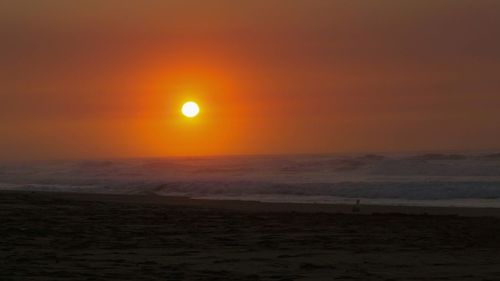 Scenic view of sea against orange sky