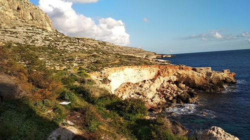 Rock formations by sea against sky