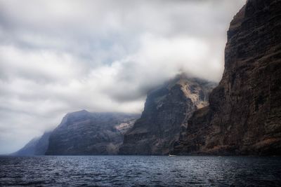 Scenic view of sea and mountains against sky