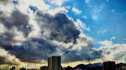 Low angle view of buildings against cloudy sky