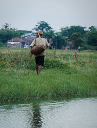 Rear view of man walking on field