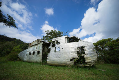 Abandoned built structure on field against sky