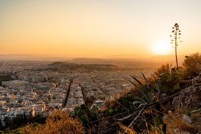Aerial view of townscape against orange sky