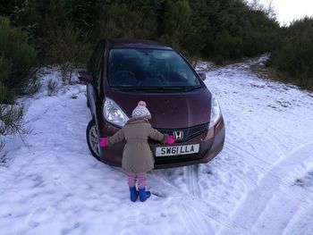 Rear view of woman on snow covered field