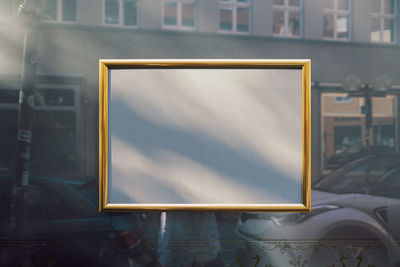 Empty golden picture frame on window