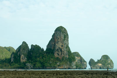 Rock formations by sea against sky