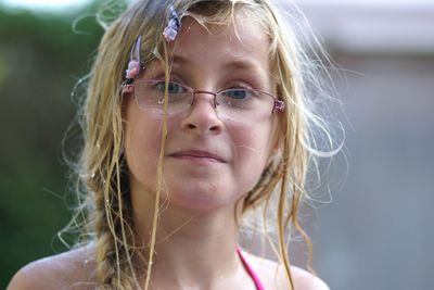 Close-up portrait of girl wearing wet eyeglasses