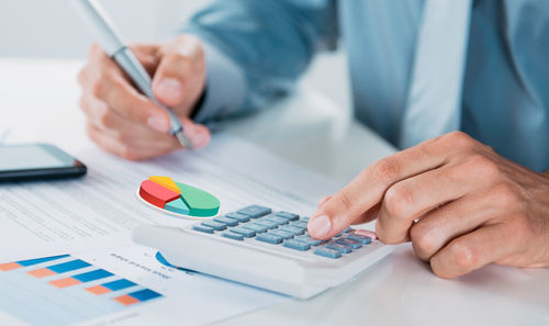 Midsection of businessman working on table