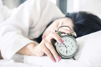 Midsection of woman sleeping on bed