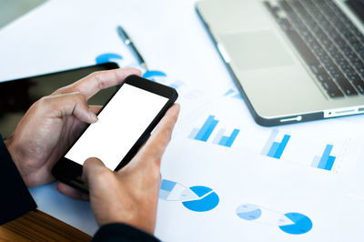 Midsection of person using mobile phone on table