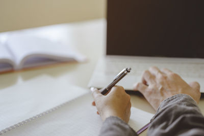 Cropped hand of business person working in office