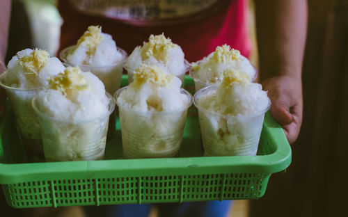 Midsection of person holding halo-halo in plastic tray