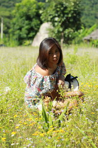 Young woman with flowers on field