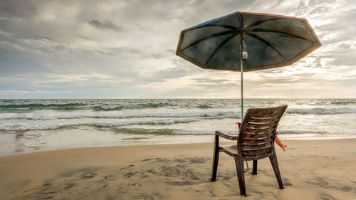 Lifeguard chair on beach against sky