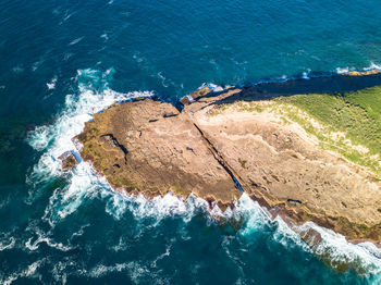 Aerial view of rocks by sea