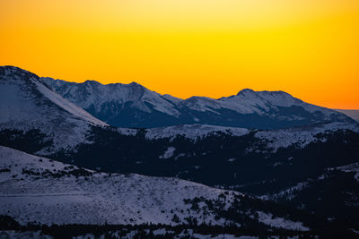 Scenic view of snowcapped mountains against sky during sunset