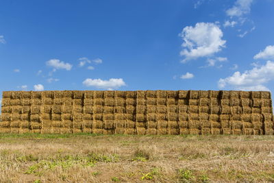 Hay bales on field against sky