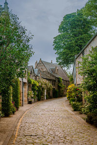 Footpath amidst buildings against sky