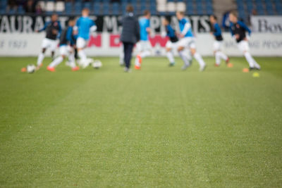 Group of people playing soccer on field