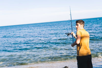 Young man fishing on beach