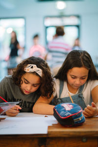 Schoolgirls together writing