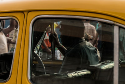 Reflection of man photographing in car