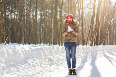 Full length of woman standing on snow covered land