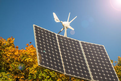 Low angle view of traditional windmill against clear blue sky