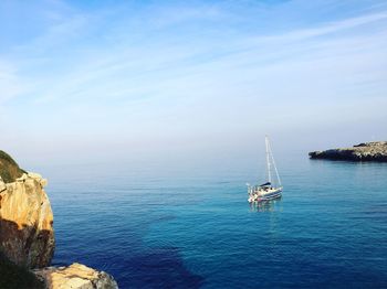 Sailboat sailing in sea against sky
