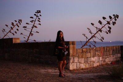 Full length of woman standing against sky