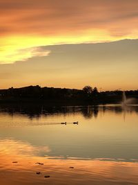 Scenic view of lake against orange sky