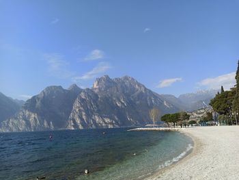 Scenic view of sea and mountains against blue sky