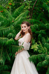 Portrait of woman standing against plants