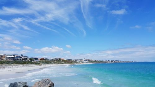 View of calm beach against blue sky