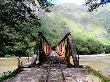 Railway bridge over river leading towards mountains
