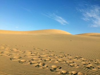 Scenic view of desert against clear blue sky