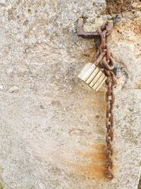 Close-up of rusty chain against wall