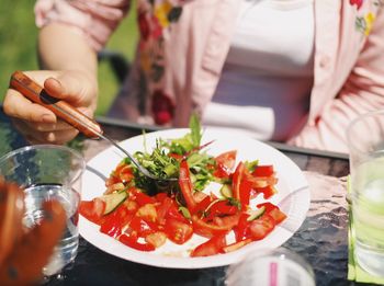 Close-up of woman having salad on table