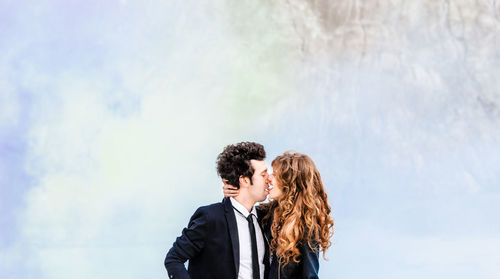 Young couple kissing against smoke