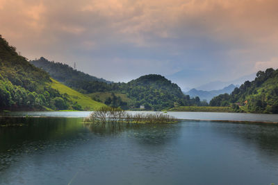 Scenic view of lake by mountains against sky