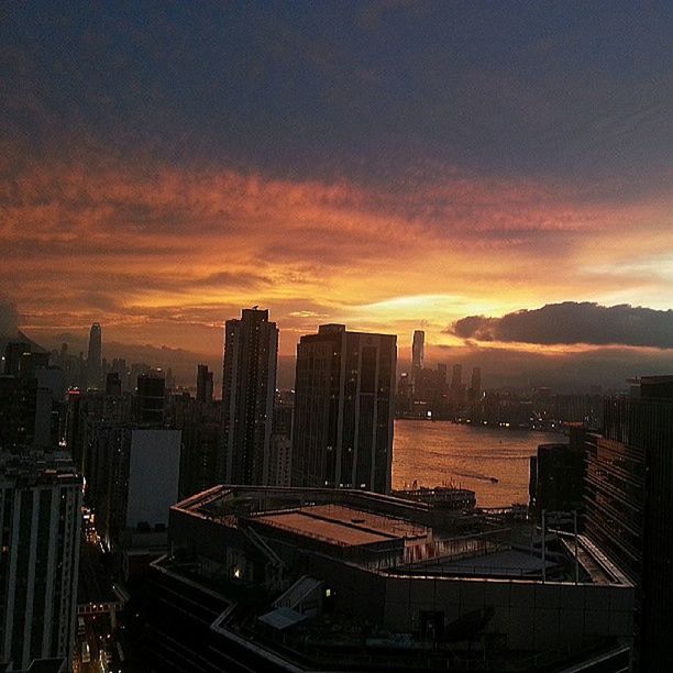 city, building exterior, sunset, architecture, cityscape, built structure, skyscraper, sky, orange color, illuminated, urban skyline, high angle view, tall - high, tower, modern, city life, office building, cloud - sky, dusk, silhouette