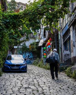 Rear view of man on street against buildings