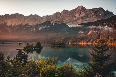 Scenic view of lake by mountains against sky